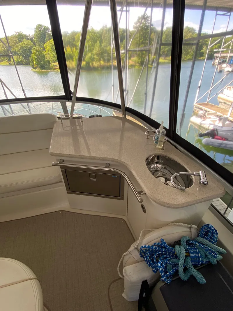 Slide: The Image of 2008 Sea Ray 47 Sedan Bridge interior with sink, counter, and scenic water view. - 29