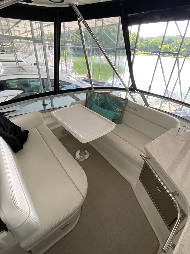 Slide: The Image of 2008 Sea Ray 47 Sedan Bridge interior with white seating, table, and scenic marina view. - 30