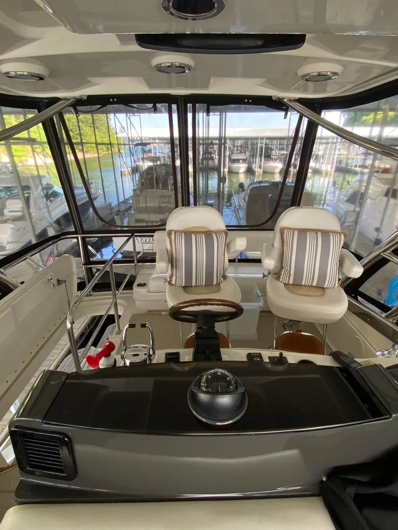 Slide: The Image of 2008 Sea Ray 47 Sedan Bridge helm with striped cushions, overlooking marina. - 31