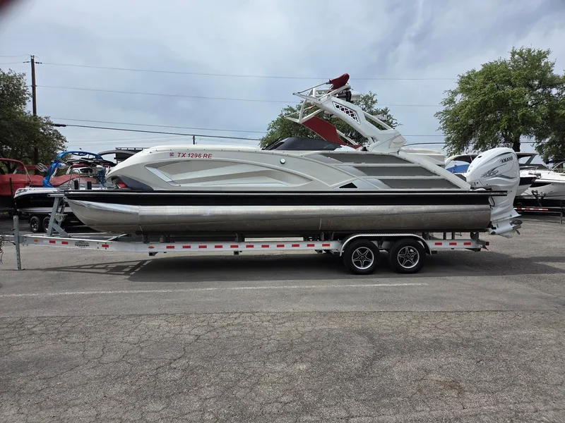 Slide: The Image of 2020 Bennington QX 25 Sport pontoon boat on a trailer, parked outdoors. - 1