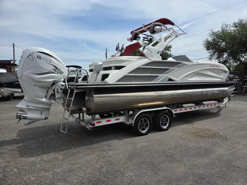 Slide: The Image of 2020 Bennington QX 25 Sport pontoon boat on trailer with Yamaha outboard motor. - 2