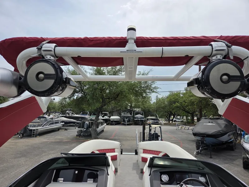 Slide: The Image of 2020 Bennington QX 25 Sport boat with speakers and red canopy in a marina. - 8