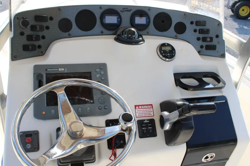 Slide: The Image of 2007 Scout 222 Sportfish boat dashboard with steering wheel and navigation controls. - 12