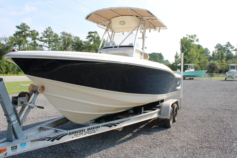 Slide: The Image of 2007 Scout 222 Sportfish boat on trailer, parked outdoors on gravel. - 2