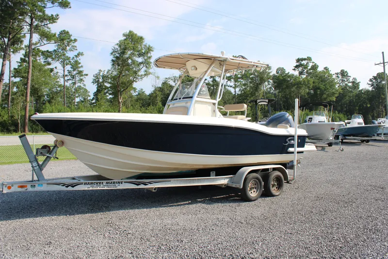 Slide: The Image of 2007 Scout 222 Sportfish boat on trailer, parked outdoors with trees in background. - 3