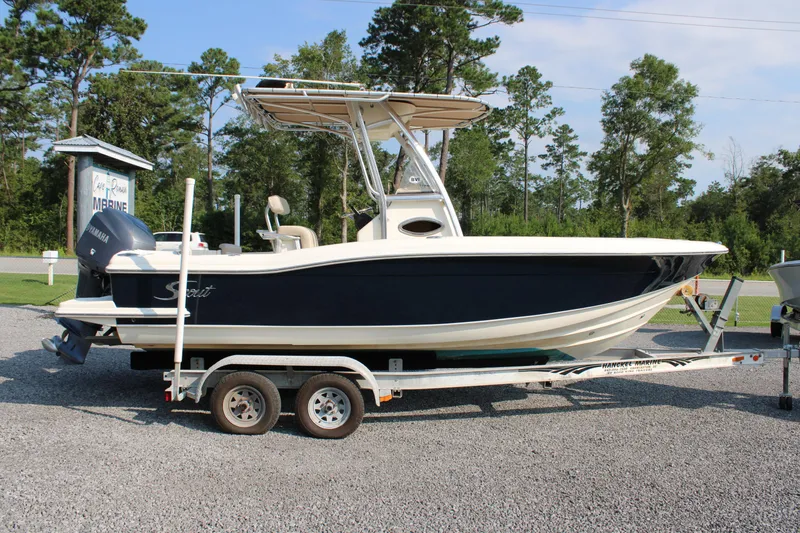 Slide: The Image of 2007 Scout 222 Sportfish boat on trailer, parked outdoors with trees in background. - 8