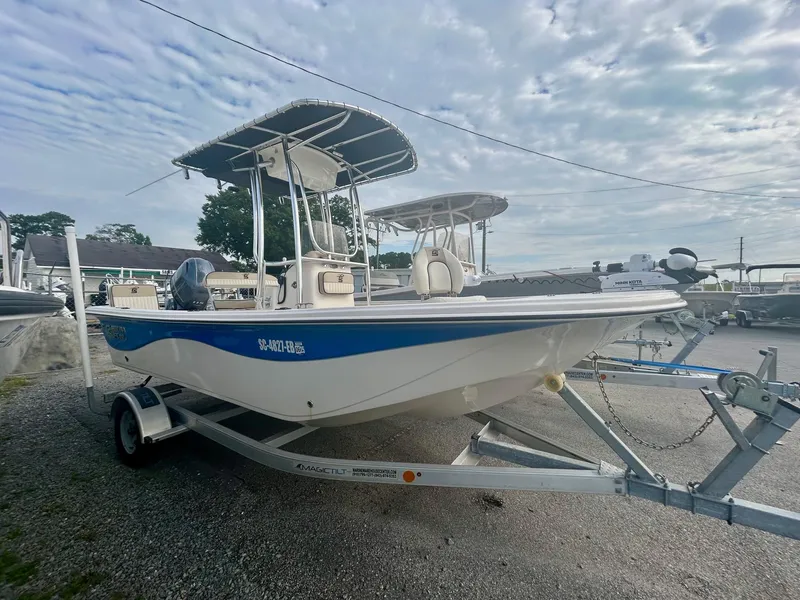 Slide: The Image of 2022 Carolina Skiff 19 LS boat on trailer, parked outdoors under cloudy sky. - 2