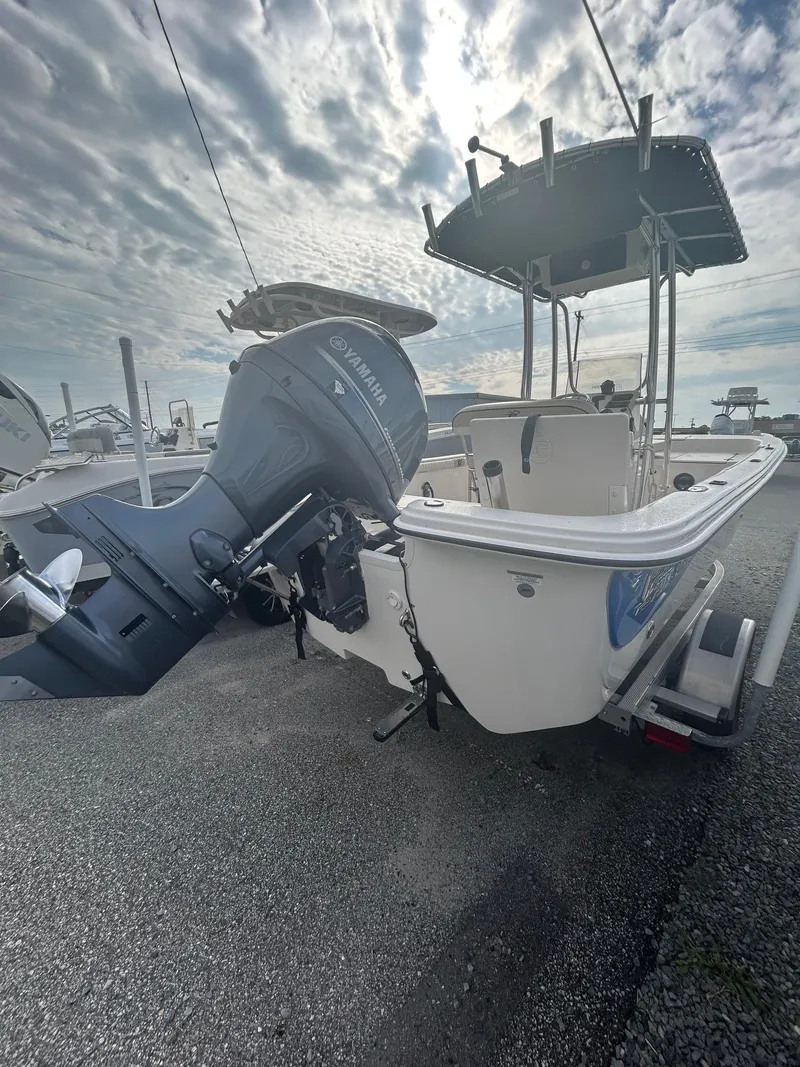 Slide: The Image of 2022 Carolina Skiff 19 LS boat with Yamaha outboard motor, parked on gravel under cloudy sky. - 3