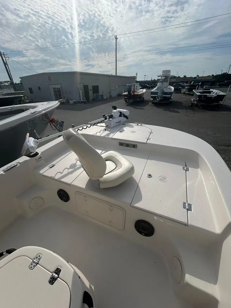 Slide: The Image of 2022 Carolina Skiff 19 LS boat interior with seating and storage, parked outdoors. - 8
