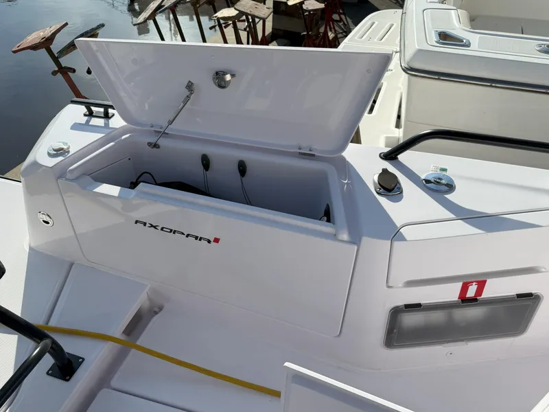 Slide: The Image of 2024 Axopar Cross Cabin storage compartment with open lid, showcasing sleek design and functionality. - 18