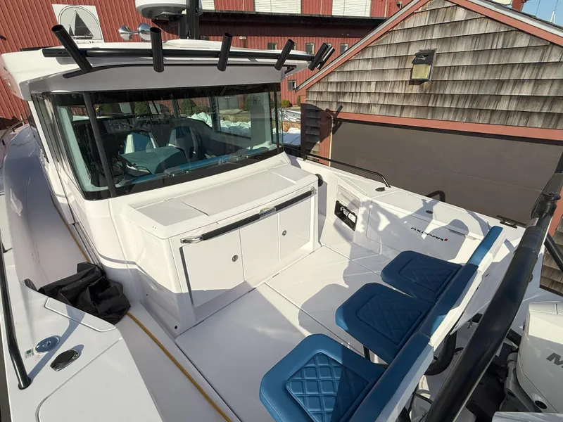 Slide: The Image of 2024 Axopar Cross Cabin storage compartments with open hatches and black mats. - 26