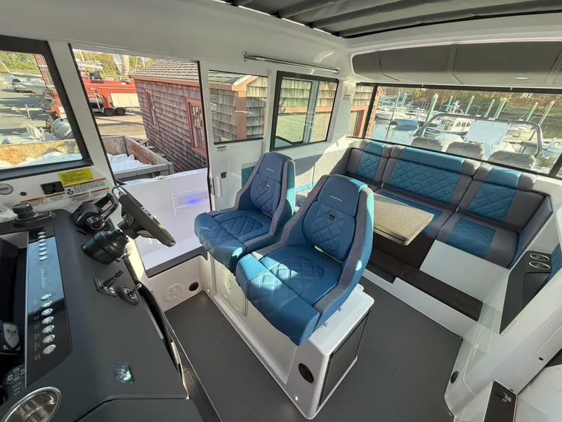 Slide: The Image of 2024 Axopar Cross Cabin interior with blue seating and a cozy lounge area. - 36