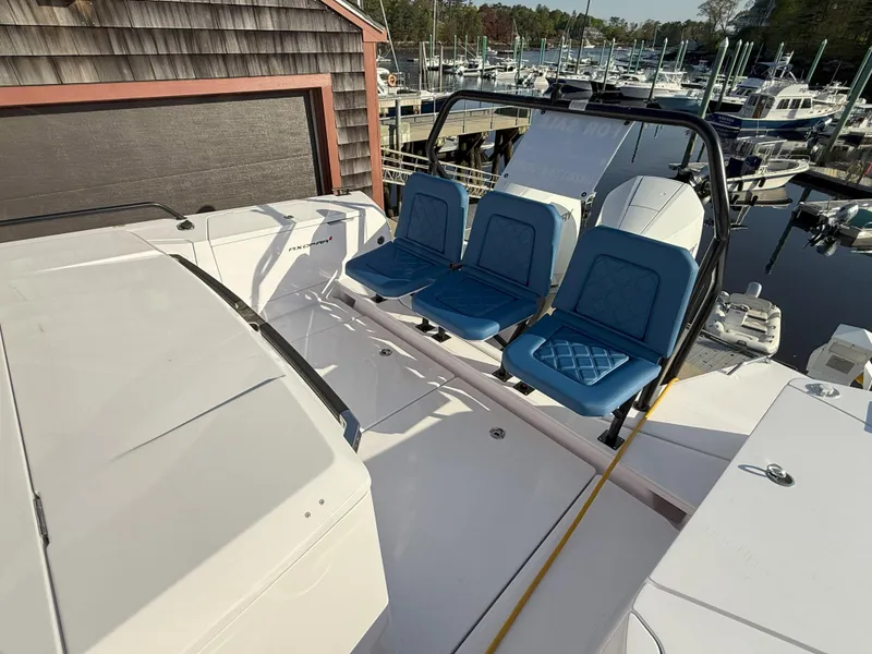 Slide: The Image of 2024 Axopar Cross Cabin boat docked at marina with seating and scenic water view. - 10