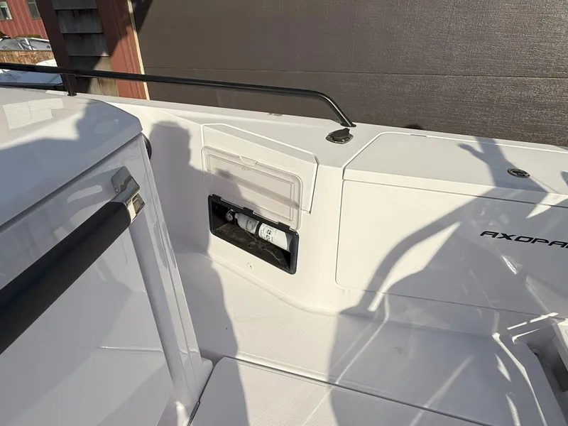 Slide: The Image of 2024 Axopar Cross Cabin fire extinguisher compartment on deck, featuring safety equipment storage. - 23