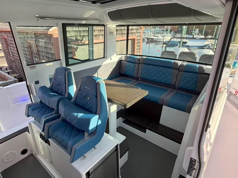 Slide: The Image of 2024 Axopar Cross Cabin interior with modern dashboard and blue seating. - 34