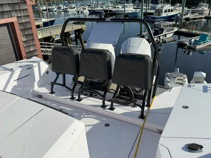 Slide: The Image of 2024 Axopar Cross Cabin boat with seating, docked in a marina. - 8