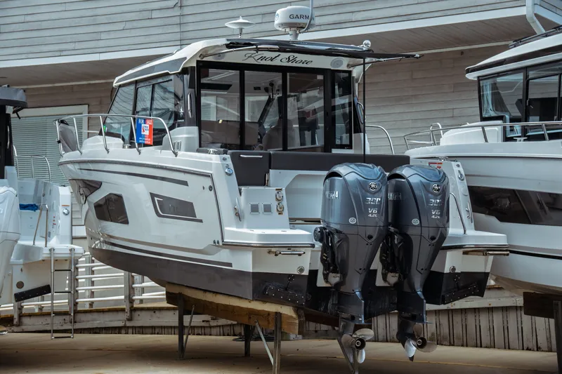 Slide: The Image of 2023 Jeanneau NC 1095 boat with dual Yamaha engines, displayed for sale at a marina. - 1