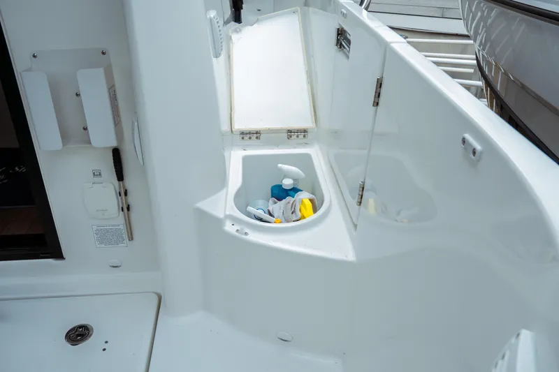 Slide: The Image of 2023 Jeanneau NC 1095 boat interior with storage compartment and cleaning supplies. - 26
