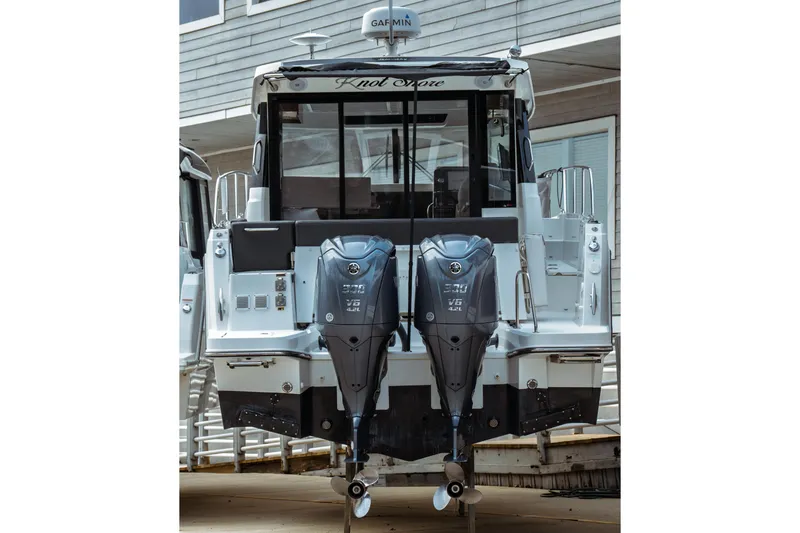 Slide: The Image of 2023 Jeanneau NC 1095 boat with dual outboard engines, docked at marina. - 3