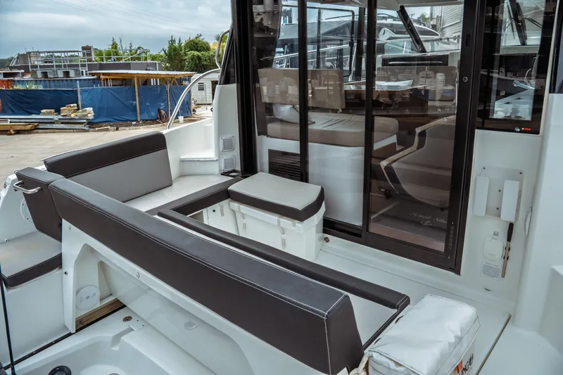 Slide: The Image of 2023 Jeanneau NC 1095 boat interior with seating and sliding glass doors. - 30