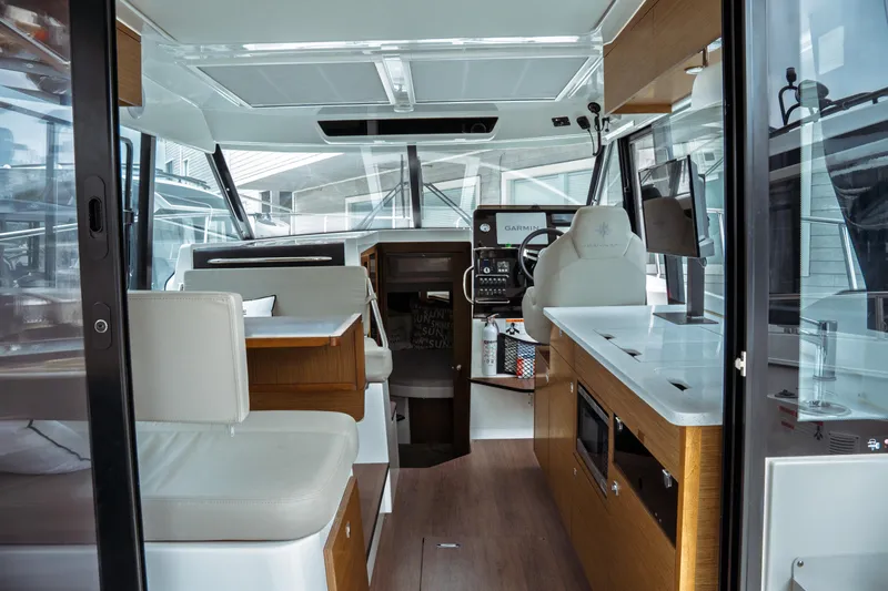 Slide: The Image of Interior of 2023 Jeanneau NC 1095 boat, featuring modern helm, seating, and kitchen area. - 34