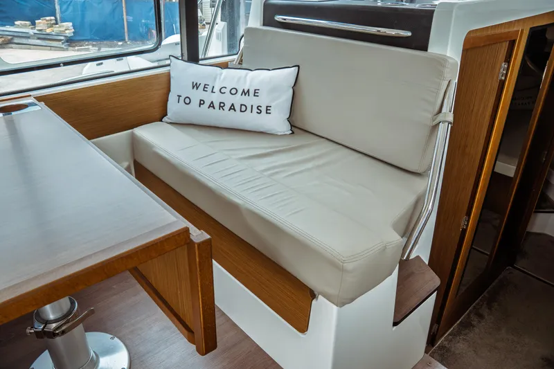 Slide: The Image of Interior of 2023 Jeanneau NC 1095 boat with cozy seating and "Welcome to Paradise" pillow. - 39