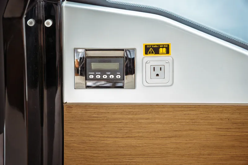 Slide: The Image of Control panel and power outlet on 2023 Jeanneau NC 1095 boat interior. - 43