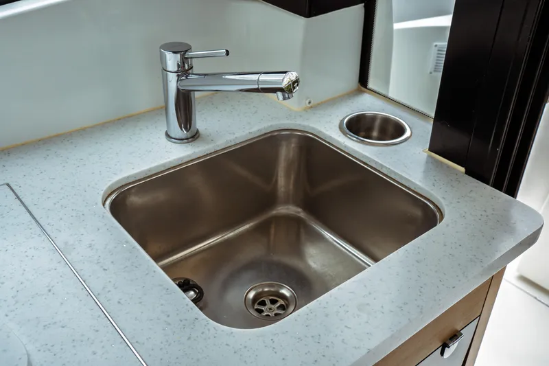 Slide: The Image of Modern kitchen sink in 2023 Jeanneau NC 1095 boat, featuring sleek faucet and countertop. - 45
