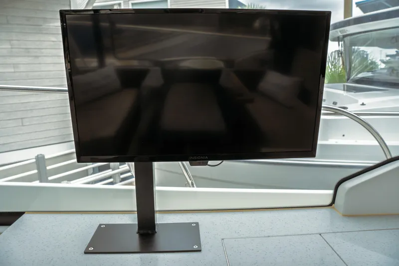 Slide: The Image of Flat-screen TV on Jeanneau NC 1095 boat, 2023 model, docked outdoors. - 48