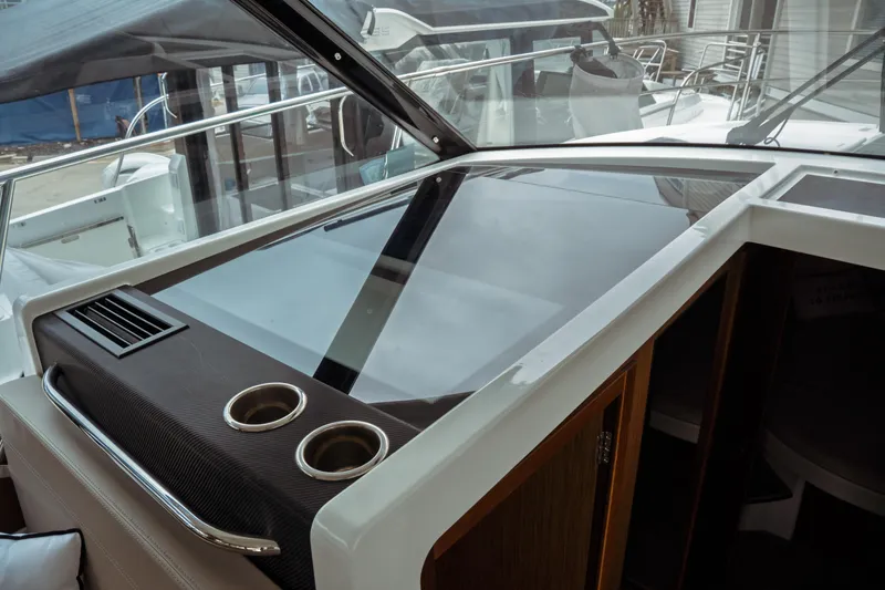 Slide: The Image of 2023 Jeanneau NC 1095 boat interior with sleek dashboard and cup holders. - 56