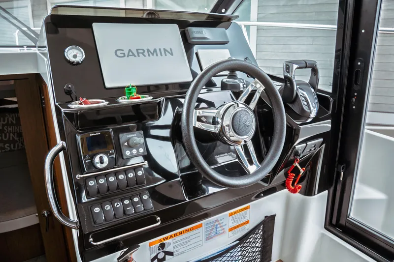 Slide: The Image of 2023 Jeanneau NC 1095 helm with Garmin navigation, steering wheel, and control panel. - 57