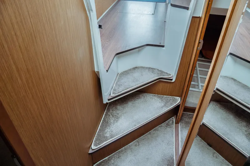 Slide: The Image of Interior stairs of 2023 Jeanneau NC 1095 boat, featuring wooden finish and carpeted steps. - 65