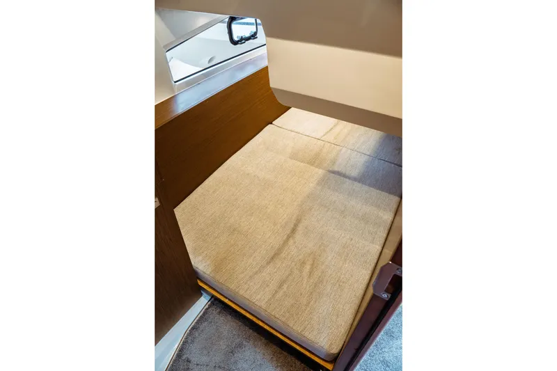 Slide: The Image of 2023 Jeanneau NC 1095 cabin interior with cozy bed and window view. - 67