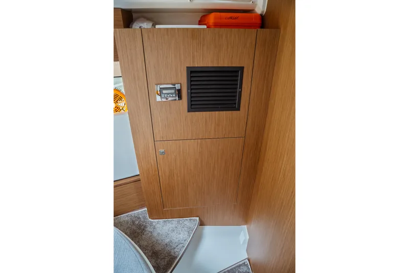 Slide: The Image of 2023 Jeanneau NC 1095 interior with wooden paneling and storage compartment. - 76