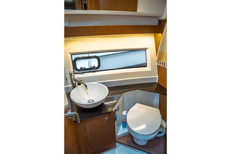 Slide: The Image of 2023 Jeanneau NC 1095 boat bathroom with modern sink, toilet, and window. - 77