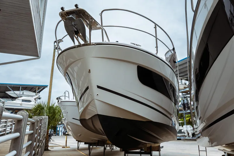Slide: The Image of 2023 Jeanneau NC 1095 boat displayed in a marina, showcasing sleek design and modern features. - 8