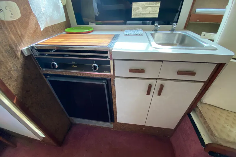 Slide: The Image of 1976 Slickcraft 28 Cruiser kitchen with stove, sink, and storage cabinets. - 10
