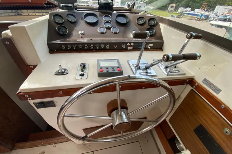 Slide: The Image of 1976 Slickcraft 28 Cruiser helm with steering wheel, gauges, and control levers. - 14