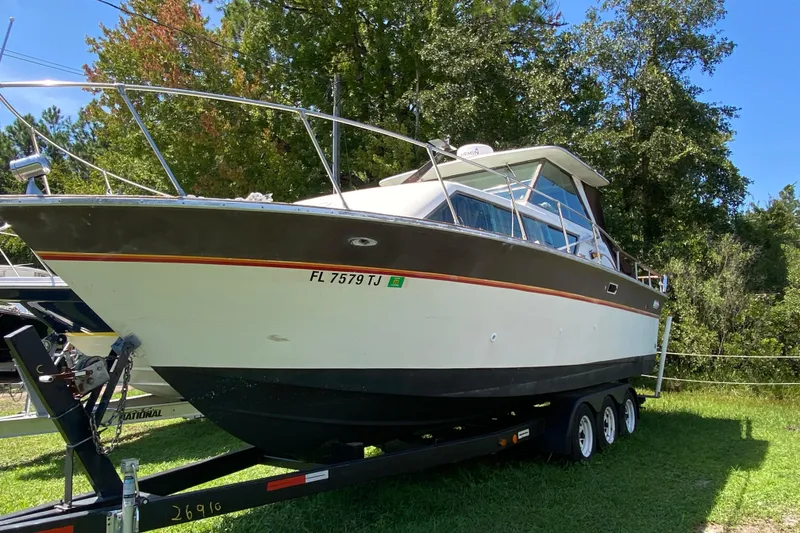 Slide: The Image of 1976 Slickcraft 28 Cruiser boat on trailer, surrounded by trees. - 4