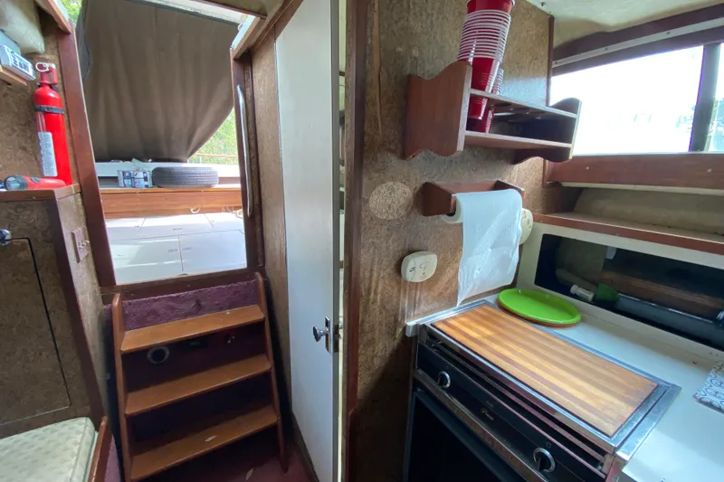 Slide: The Image of 1976 Slickcraft 28 Cruiser interior with kitchenette, stairs, and storage shelves. - 6