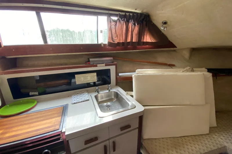 Slide: The Image of 1976 Slickcraft 28 Cruiser interior with kitchenette, sink, and seating area. - 8