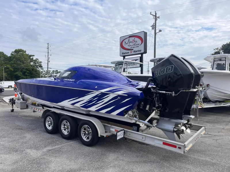 Slide: The Image of 2018 Lavey Craft 28 EVO boat on trailer, blue with white accents, parked at marina. - 3
