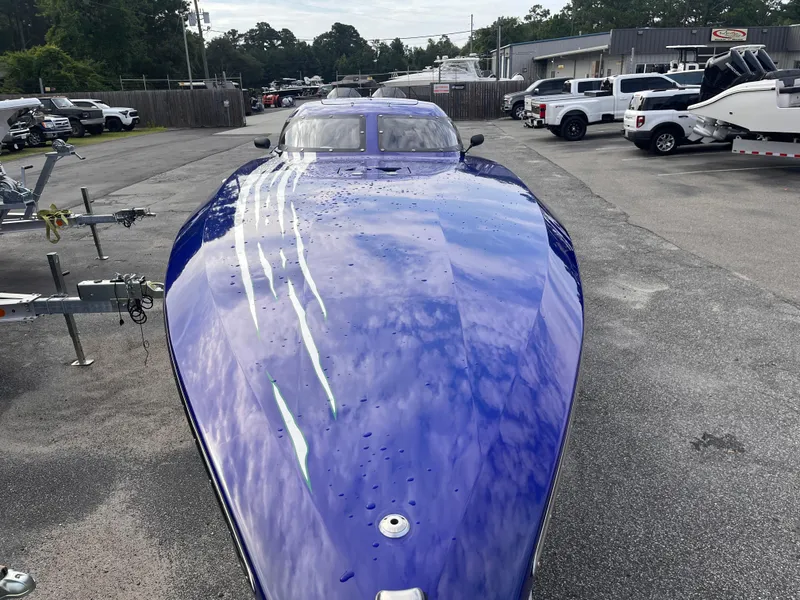 Slide: The Image of 2018 Lavey Craft 28 EVO boat with sleek blue design in a parking lot. - 7