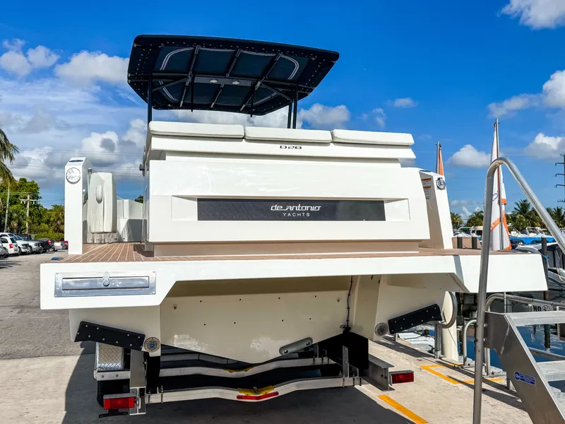 Slide: The Image of 2024 De Antonio Yachts D28 Open, rear view, docked under clear blue sky. - 4