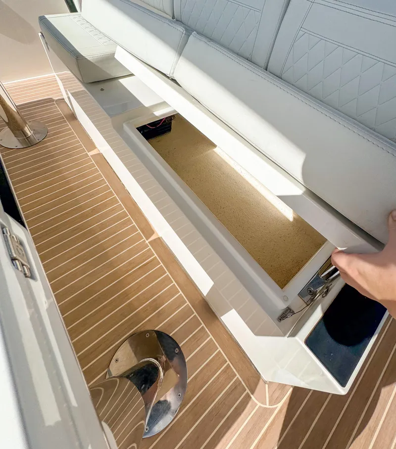 Slide: The Image of 2024 De Antonio Yachts D28 Open storage compartment with white seating and wooden deck. - 9