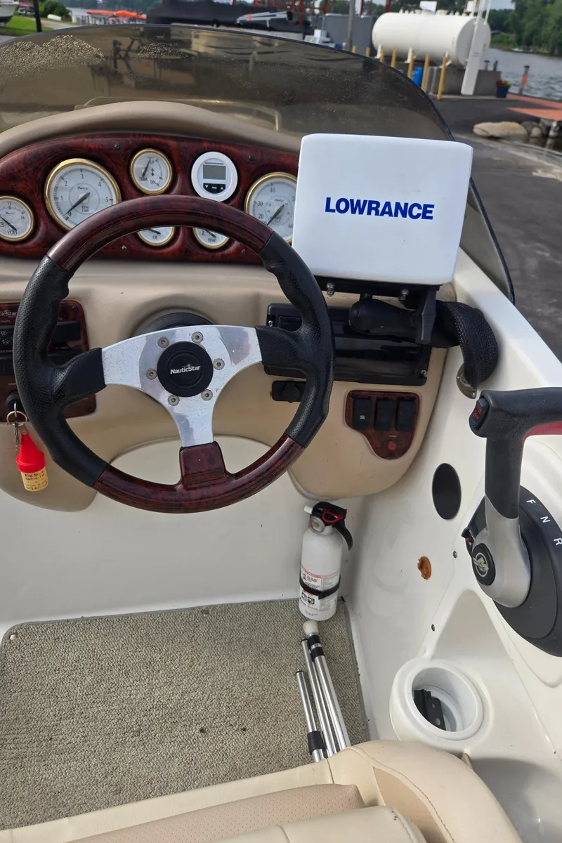 Slide: The Image of 2005 NauticStar 210 Sport Deck I/O dashboard with steering wheel and Lowrance navigation system. - 3