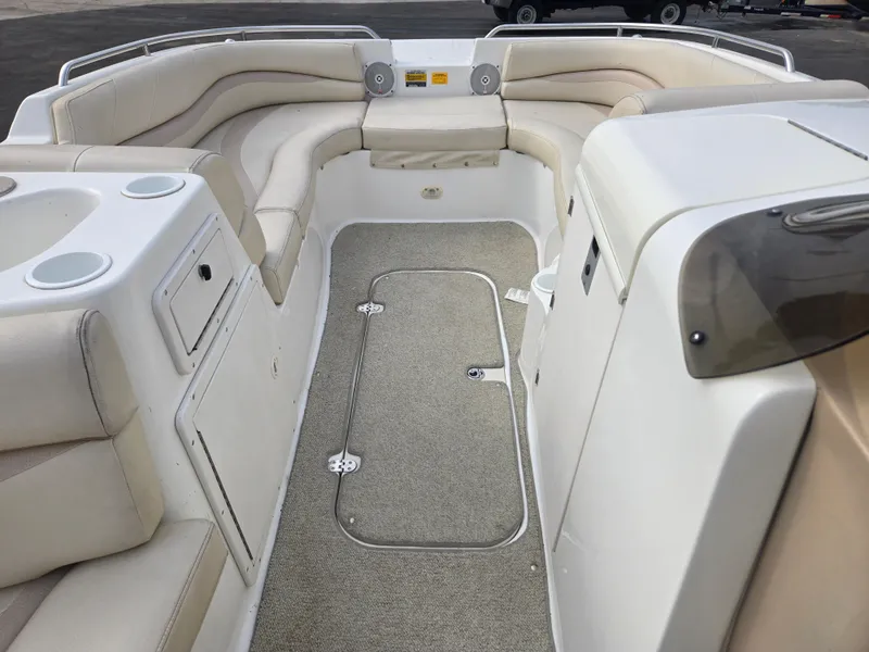 Slide: The Image of 2005 NauticStar 210 Sport Deck I/O interior with beige seating and carpeted floor. - 5