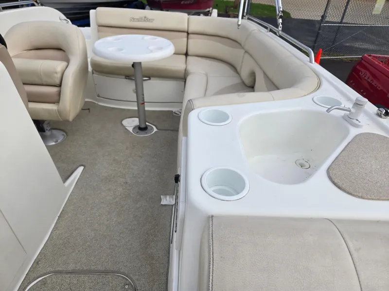 Slide: The Image of 2005 NauticStar 210 Sport Deck I/O interior with seating, table, and sink. - 7