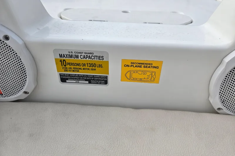 Slide: The Image of NauticStar 210 Sport Deck I/O 2005 boat capacity label, seating recommendation, and speakers. - 8