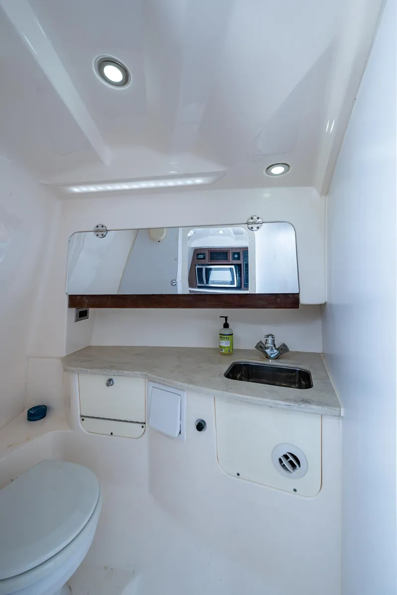 Slide: The Image of 2014 Everglades 350LX boat bathroom with sink, mirror, and toilet. - 11